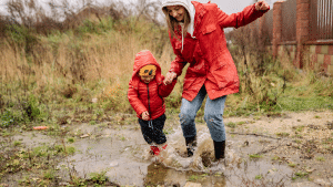 Mother and son jumping in puddle together